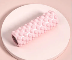 Pink textured roller on a white plate with a pink background