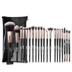 Set of makeup brushes with black and rose gold handles in front of a black pouch on a white background.