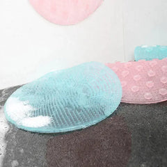 Blue and pink bath mats on a gray surface with water droplets.