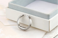 Silver ring device on a white surface with a soft focus background