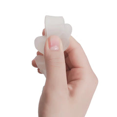 Hand holding a white silicone toe separator against a white background