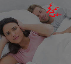 Woman lying in bed with a man, both looking uncomfortable, with red lightning bolts above them.