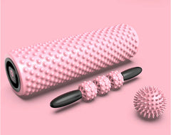 Pink foam roller with black accents on a pink background