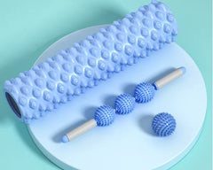 Blue massage roller and balls on a light green background