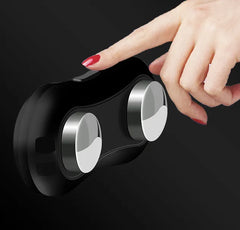 Hand interacting with a black and silver device on a dark background