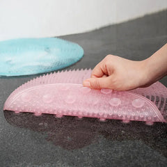 Pink textured mat with a hand showing suction cups on it, next to a blue mat on a dark surface.