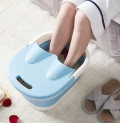 Person using a blue foot bath on a white carpet