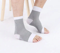 Person wearing black and white striped ankle socks on a white background